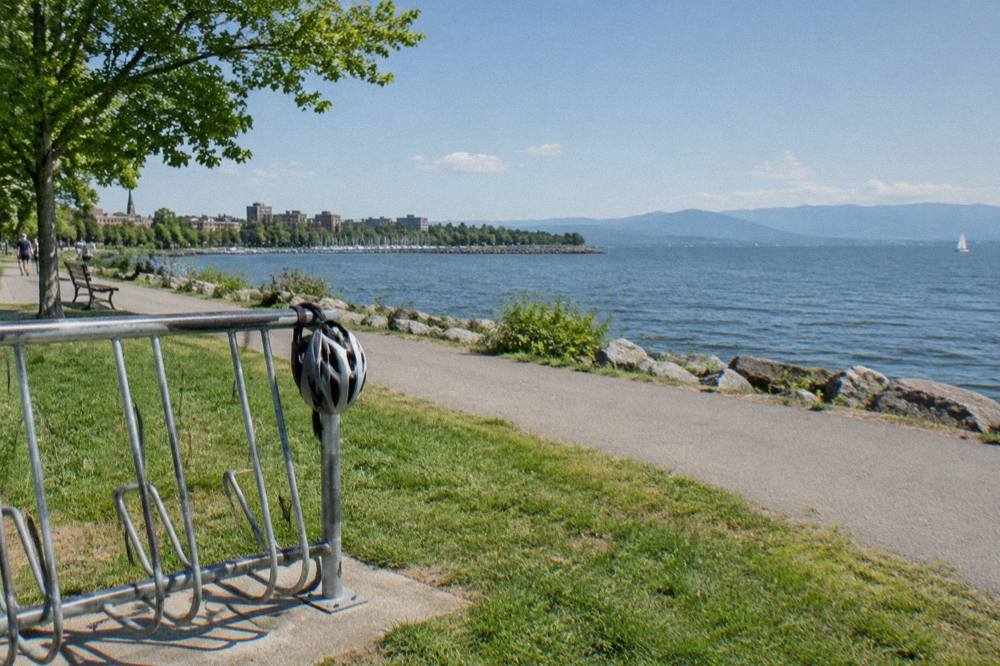 Bikes lined up on a rack beside a lakefront path