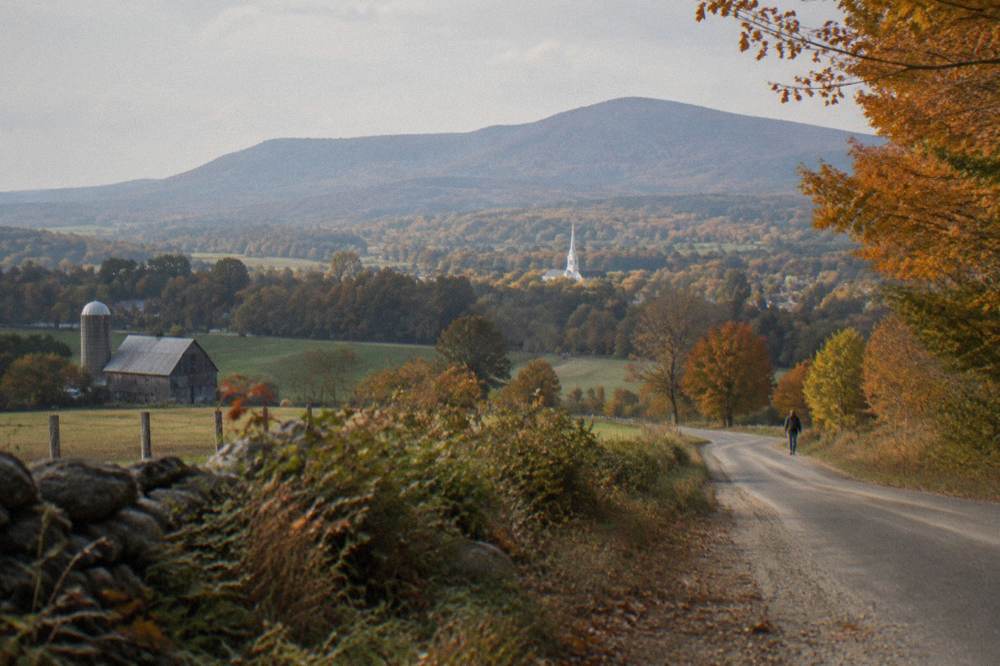 A winding country road through a southern Vermont valley with late-season orange trees