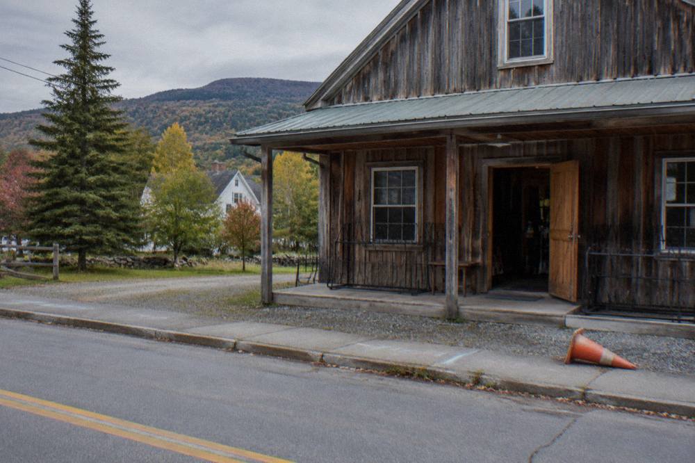 A row of rental mountain bikes parked outside a wooden bike shop in a small village