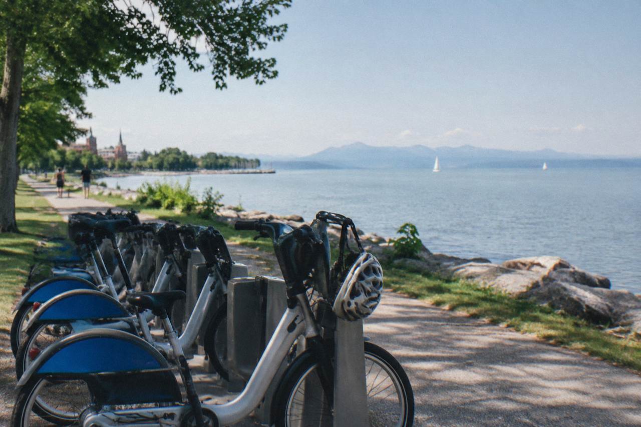 Bicycles parked beside a lakefront bike path on a clear morning