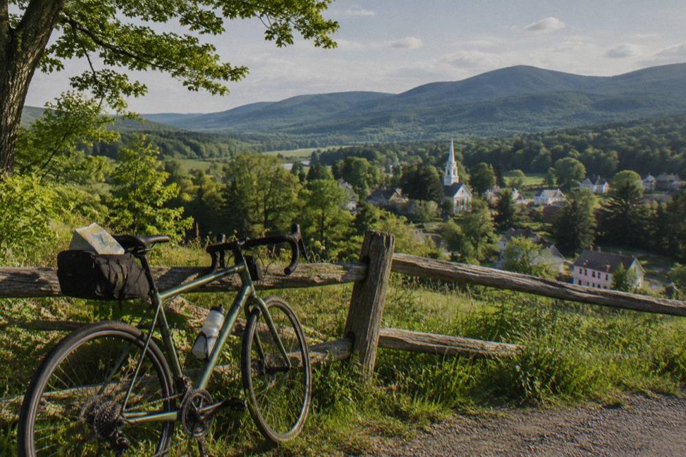 A road bicycle leaning against a wooden fence above a Vermont valley