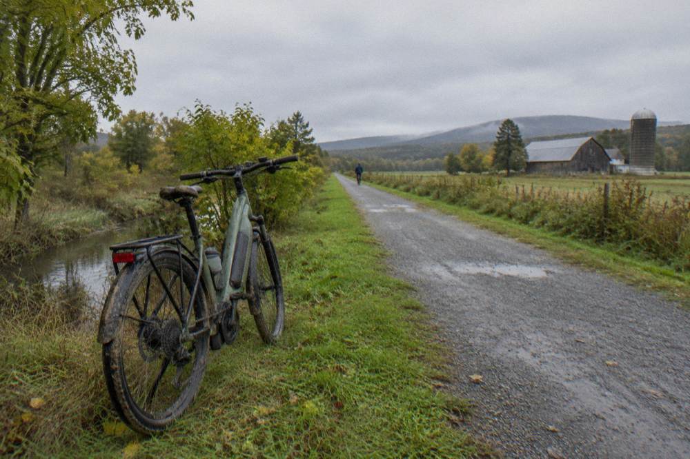 An electric assist bike parked at the edge of a gravel rail trail in rural Vermont